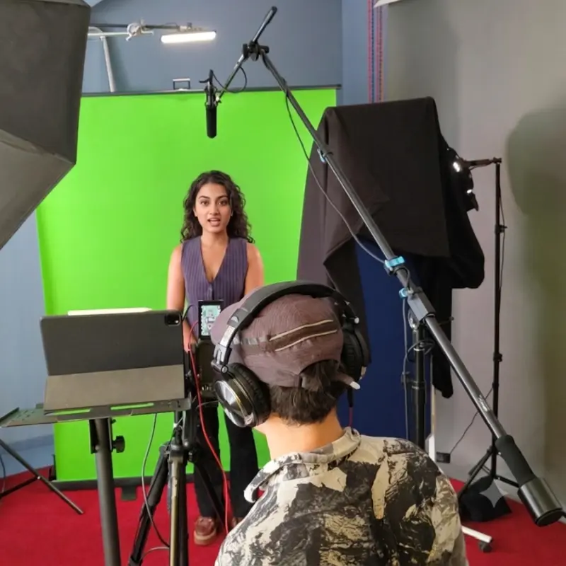 Junge Frau spricht ein YouTube Video vor einem Greenscreen ein in den Meeet-Studios, Berlin