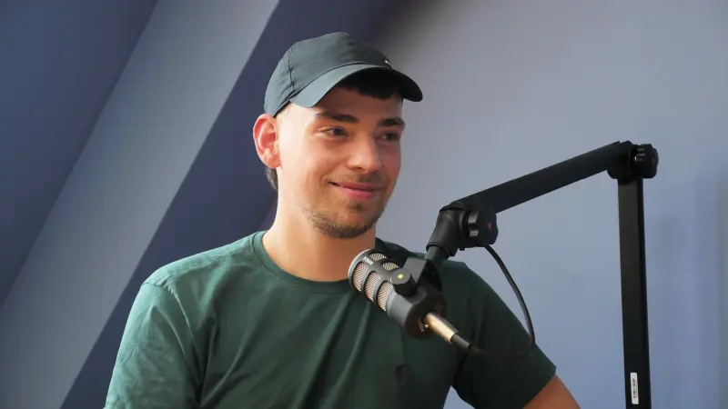 Podcast Set Konrad 1 mM TN rechts 800 Podcast-Set im Studio Konrad bei Meeet Studios in Berlin Neukölln: Person links am Tisch vor hellblauer Wand mit Mikrofon