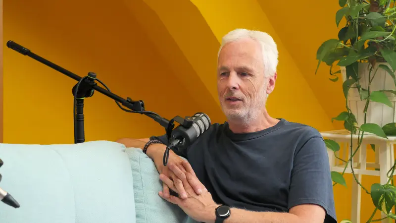 Podcast Set Konrad 3 mM TN rechts 800 Podcast-Set im Studio Konrad bei Meeet Studios in Berlin Neukölln: Eine Person auf einem mintgrünen Sofa, Mikrofon auf Mikroständer